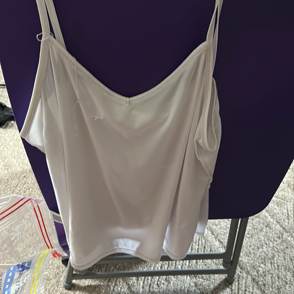 Beautiful white tank top has a small Nick in it